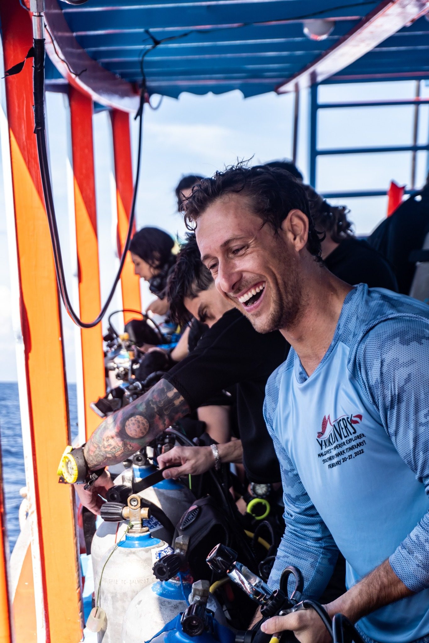A divemaster setting up scuba tanks and regulators on the dive boat, Koh Tao