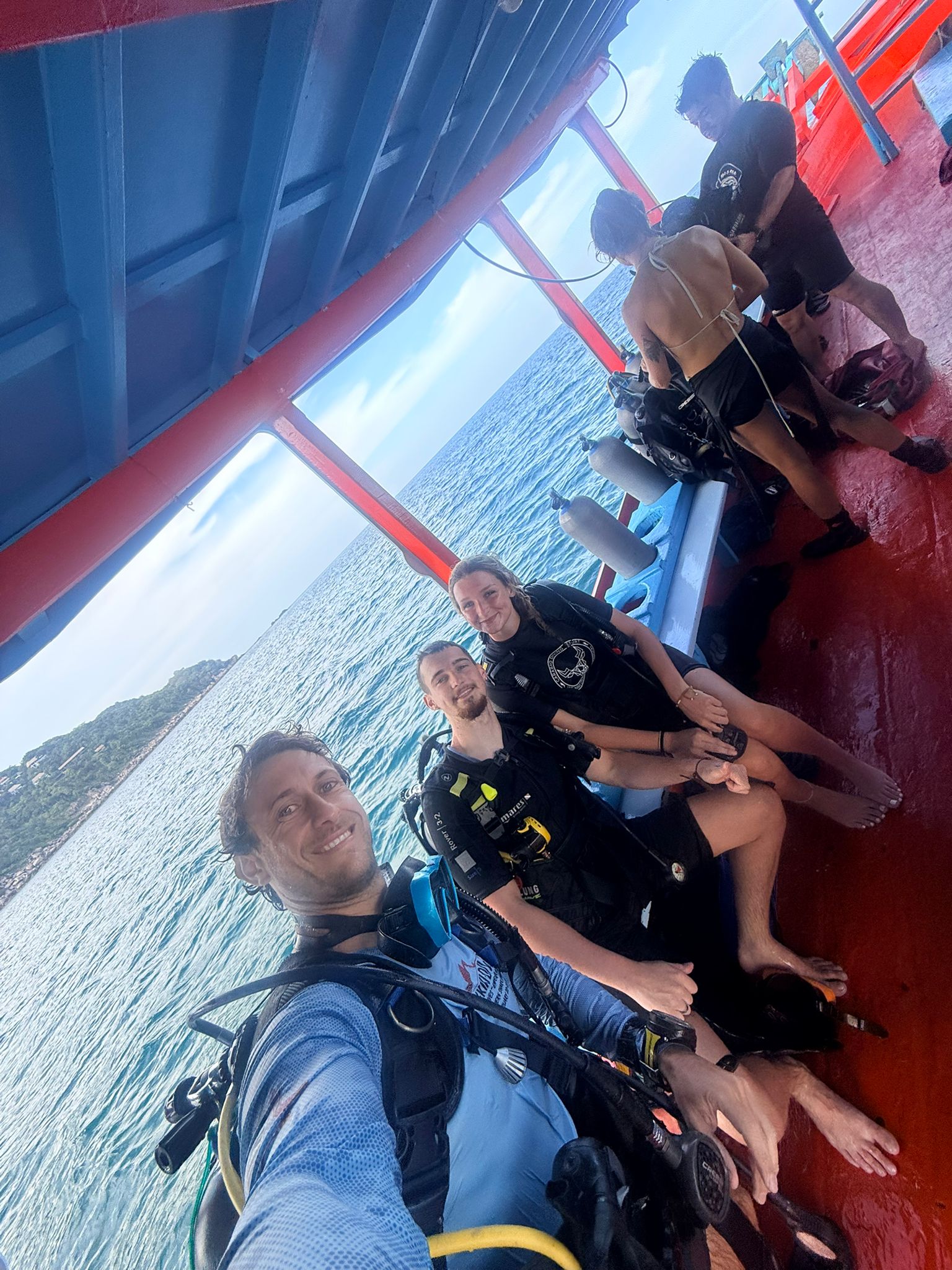 Two Carabao team members giving thumbs up from a longtail boat on Chalok Bay beach