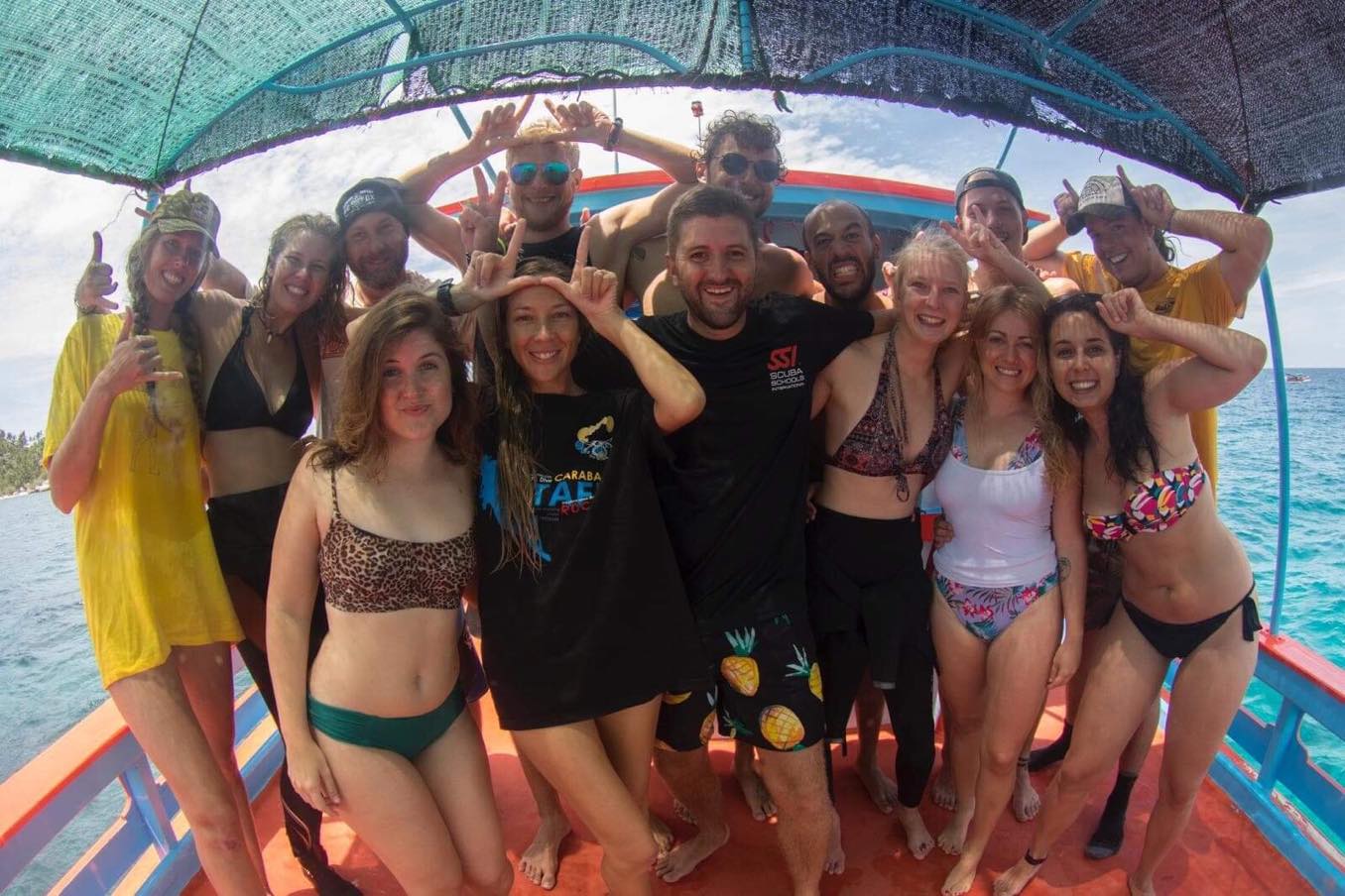 The Carabao Diving crew laughing together on the dive boat off Koh Tao